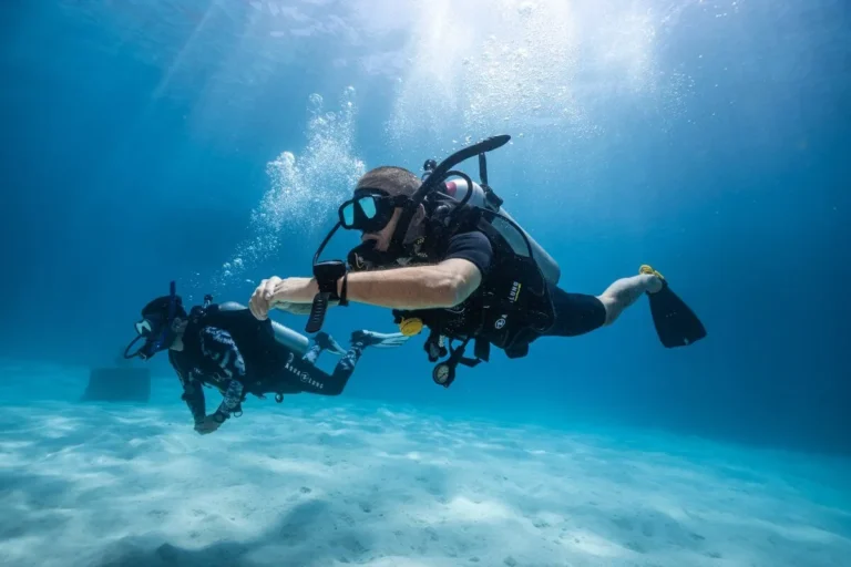 Buceador acompañado por un instructor durante un bautismo de buceo seguro
