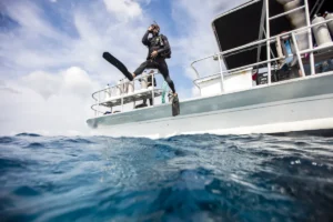 Buceador entrando al agua desde un barco para iniciar una inmersión en Tenerife