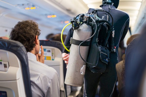 Buceador revisando el tiempo de espera antes de volar después de bucear