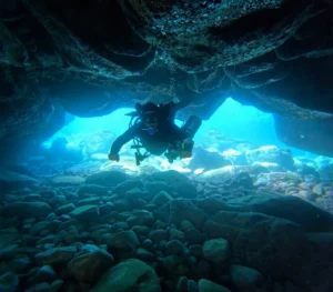 Scuba diver exploring a volcanic underwater cave during a dive in South Tenerife