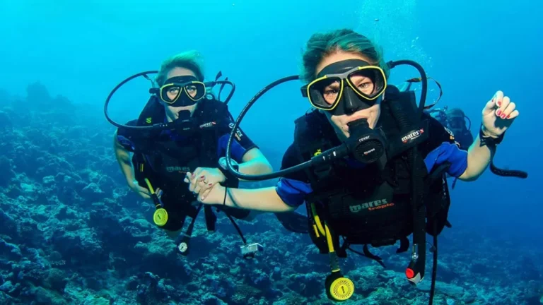 Instructor accompanying a beginner female diver during a Discover Scuba Diving experience