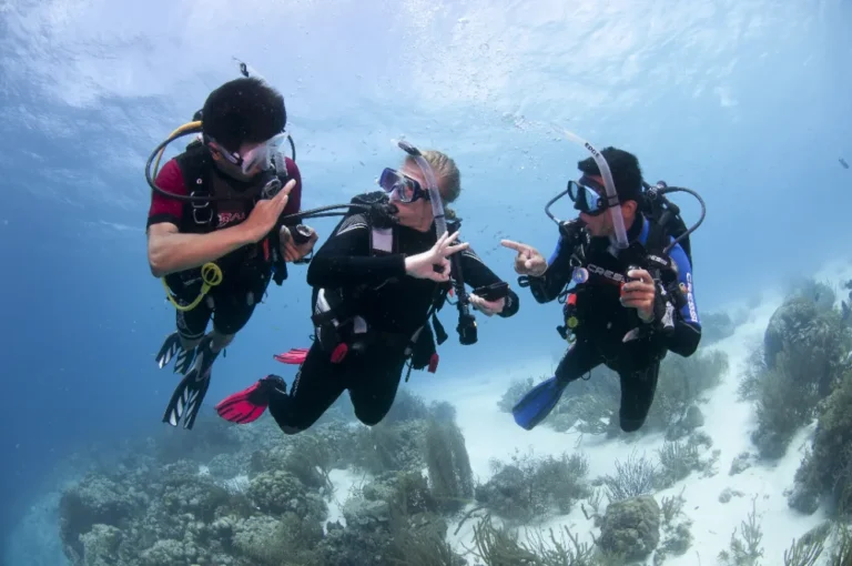 Instructor giving instructions to two divers during a Discover Scuba Diving experience