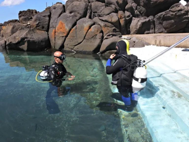 Divers walking from the shore with scuba gear ready to start a shore dive in Tenerife