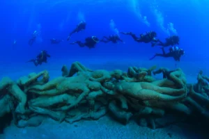 Grupo de buceadores junto a una estatua del Museo Atlántico en Playa Blanca, Lanzarote