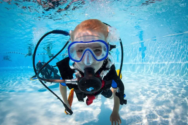 Child around 10 years old learning to scuba dive during a Junior Open Water Diver course