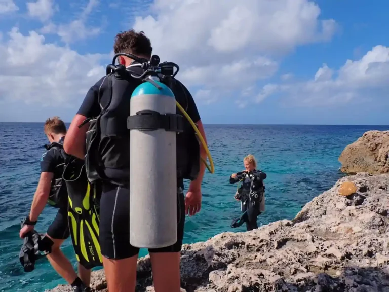 Divers walking from the shore to start a shore dive in Lanzarote